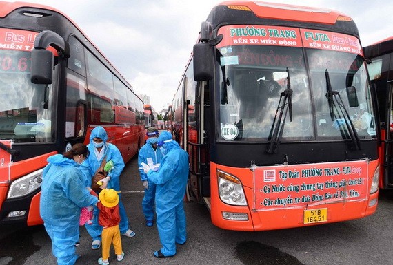 民眾穿著防護服準備搭乘免費班車離開本市返回福安省。