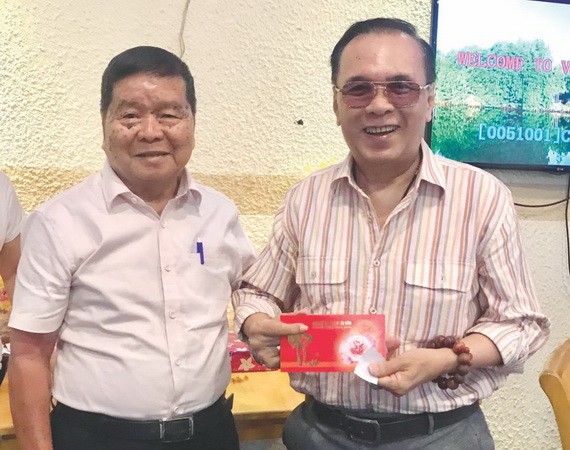 春聚上，何德明（左）向團員發送獎品。