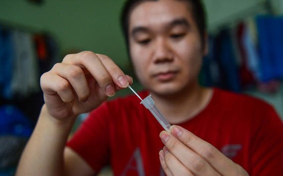 一名男性在家自行做快速檢測。（圖：光定）