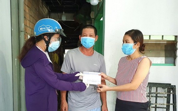 “一家庭幫助一家庭”行動代表人向黎文昆(家住平盛郡第二十八坊)贈送輔助金。