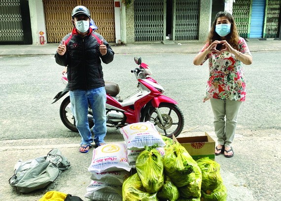 何麗娟(右)把救濟品轉交某單位負責人。