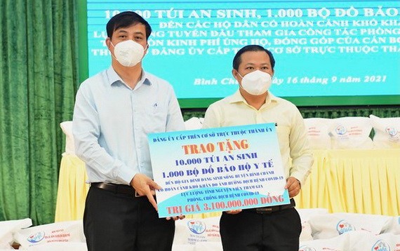 市人委會副主席黎和平（右）向平政縣移交民生用品及防護服。（圖源：越勇）