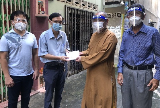 市華人佛教代表釋慧功(左三)與麒麟(左一)向平泰華文中心教務主任許少宏贈送慰問金。