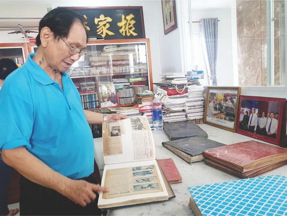 張漢明書畫家在整理剪報冊。