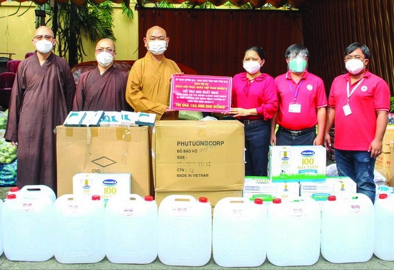 第八郡佛教會執行會長釋慧功法師向郡祖國陣線委員會副主席范氏明月轉交物資。