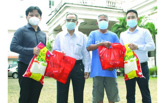 本報編委文忠孝(右一)與“西堤華人文化陳列室”計劃負責人麒麟(左一)向報販贈送禮物。