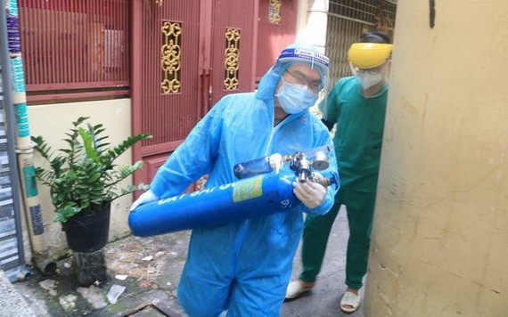 國防部軍醫學院阮維新醫生抱著氧氣瓶，與第六郡第一坊醫療站人員配合急救呼吸困難確診者。