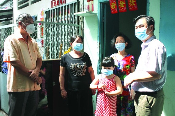 市民族處副主任曾福祿(右一)和第十郡人委會副主席裴世海(左一)向一華人戶贈送資助金。