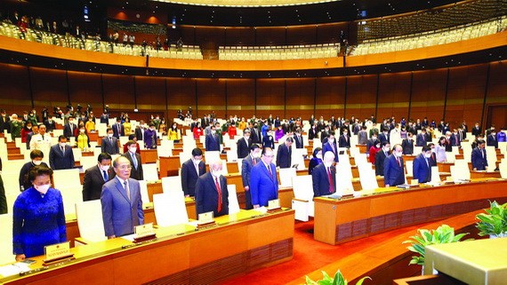 與會代表為悼念新冠逝者默哀一分鐘。（圖源：越通社） 