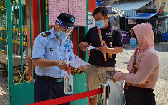 溫陵會館保安員檢查進廟善信的注射疫苗證件。