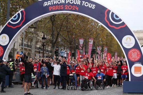 基普喬格、巴黎奧組委主席埃斯坦蓋（前左一）等與參賽選手在賽前自拍。（圖源: 互聯網）