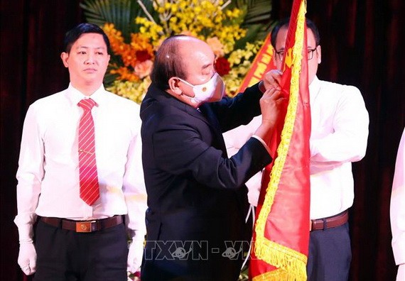 國家主席阮春福為河內師大傳統旗幟別上一等勞動勳章。