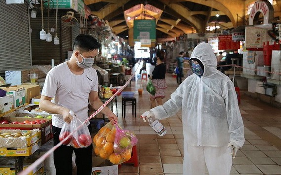 民眾在第一郡濱城市場購物時穿防護服、消毒及 保持安全距離。