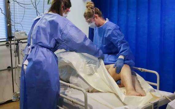 2021年11月19日，醫護人員在比利時安特衛普的一家醫院照顧新冠死者的屍體。（圖源：路透社）