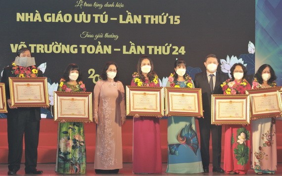 市委副書記、市人民議會主席阮氏麗與市委委員、市人委會副主席楊英德向各教師頒發優秀教師稱號。（圖源：越通社）