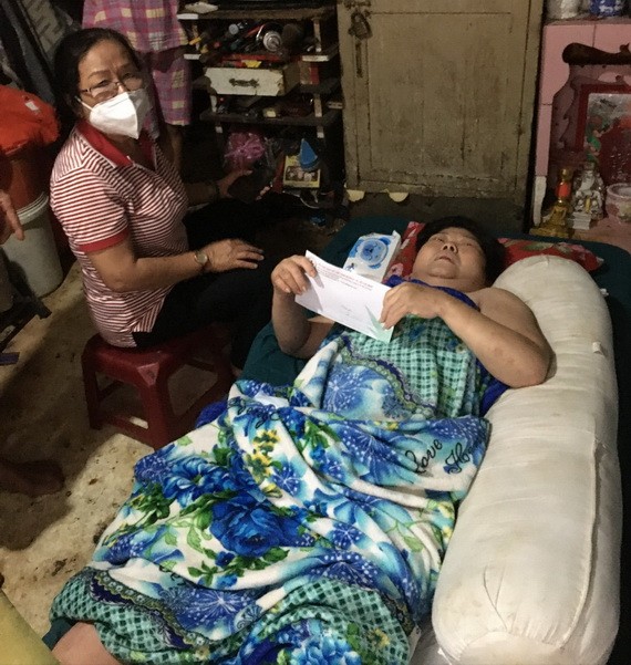 躺在長椅上的李金英伸手接過志願員送來的輔助金。