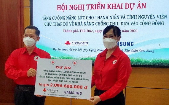 本市的項目負責人陳文俊向守德市紅十字會主席鄧陳源草轉交經費。