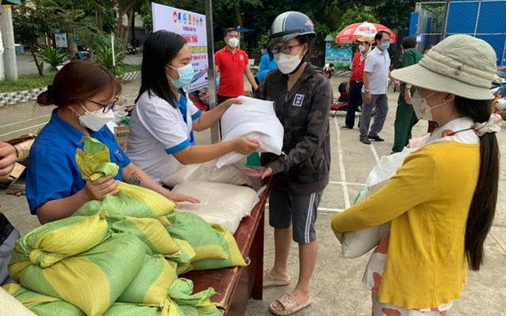 當地民眾積極響應“垃圾換取大米”活動，一大早就紛紛把一袋袋垃圾送到回收點換取大米後，興高采烈地抱著一包包大米回家。（圖：友真）