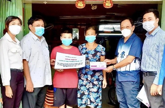 麥漢強先生(右二)與地方政府代表向第六郡第三坊孤兒贈送生活費。