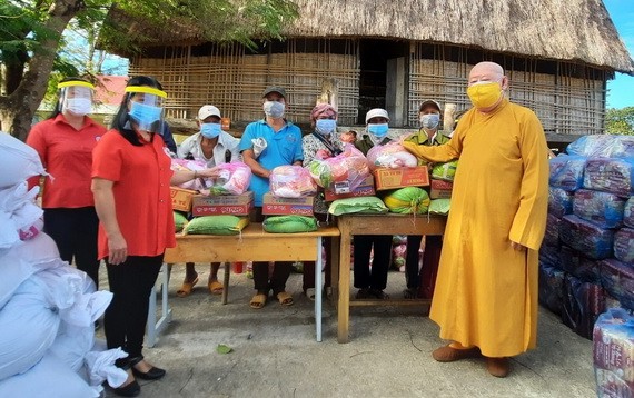 蓮華寺住持釋惟鎮法師（右一）向貧困少數民族同胞派發救濟品。