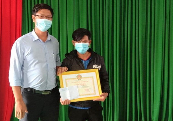 廣義省李山島縣人委會代表向陳英勇船長（右）頒發獎狀。（圖：阮莊）
