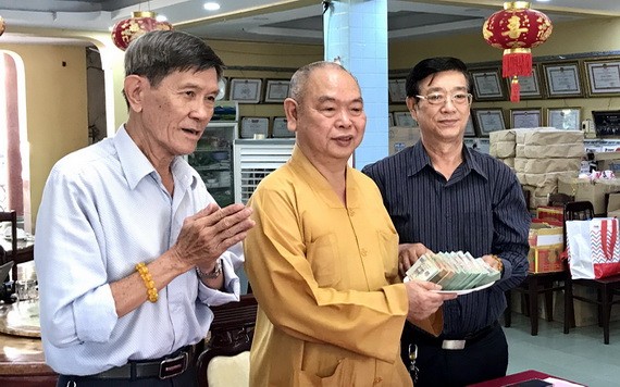 龍華寺護法會會長鄧栢榮(右)向釋慧功和尚移交善款。