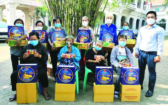 本報編委文忠孝(右)向華人貧困同胞贈送禮物。