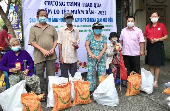 紅十字會領導與丁文森先生向清寒人家發送新春禮物。