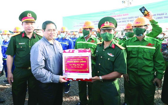 政府總理范明政向項目施工的工程師與工人贈送禮物。