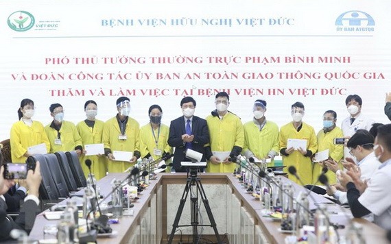 政府常務副總理范平明（中）同越德友誼醫院領導、醫務工作人員合照。（圖：越通社）