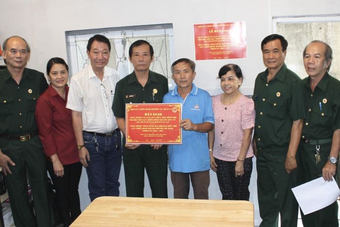 郡、坊退伍軍人協會代表與茶山慶雲南院住持周華邦(左三)向退伍軍人移交修繕“同隊屋”工程。