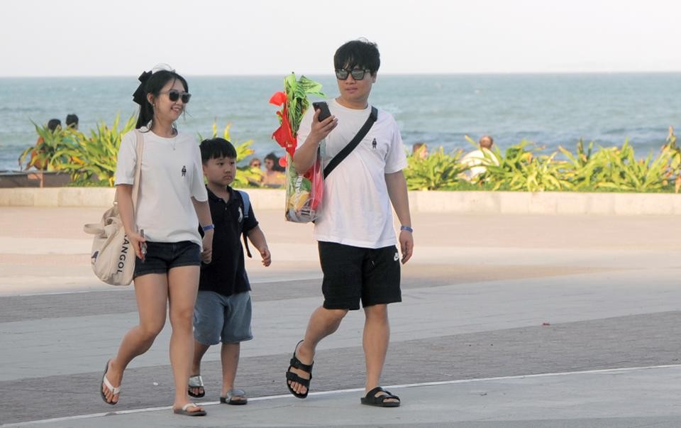 一個三口之家小家庭的韓國遊客在遊逛芽莊海邊風光。（圖：中宇）