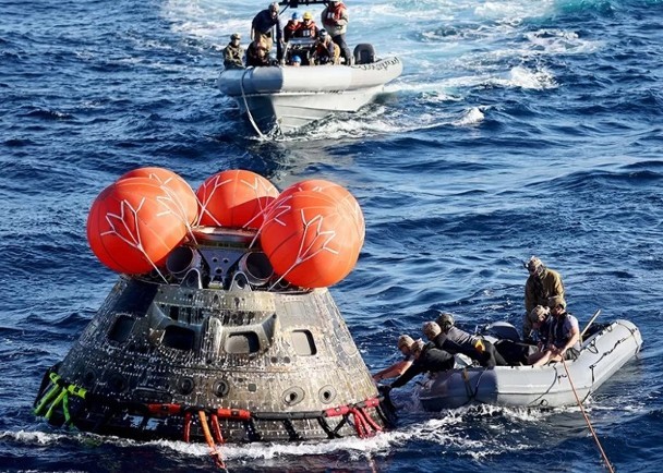 工作人員把降落後的獵戶座太空船固定。（圖：AP）