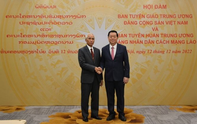 中央宣教部長阮仲義（右）與老撾人民革命黨中央書記、黨中央宣訓部長坎潘‧佩亞翁握手合照。（圖：越通社）