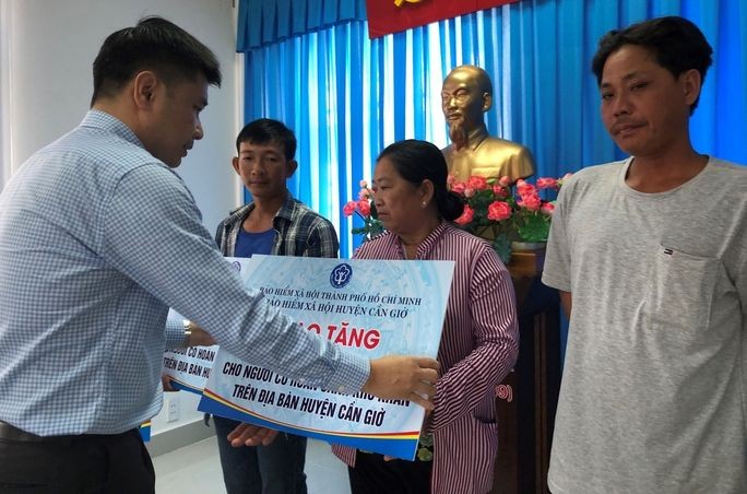 市社保機關代表向芹耶縣貧困者贈送社保冊。