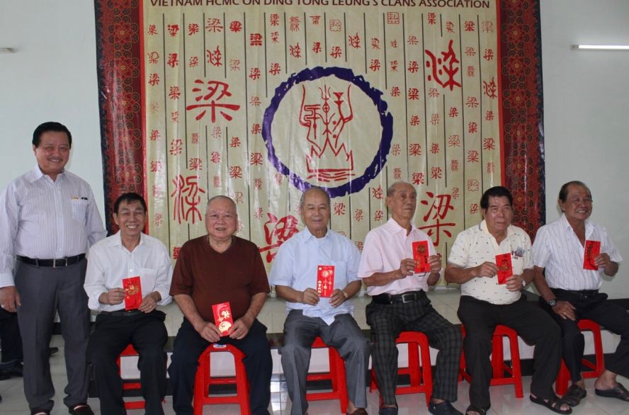 梁氏宗祠理事长梁万荣(左一)向七十岁以上的长者派发敬老礼物。