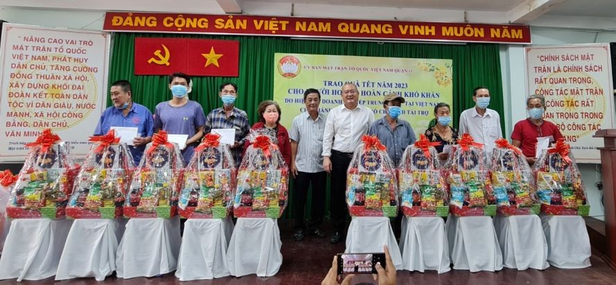 赵骞会长和第十一郡越南祖国阵线委员会副主席林圆德向贫户派发春节礼物。