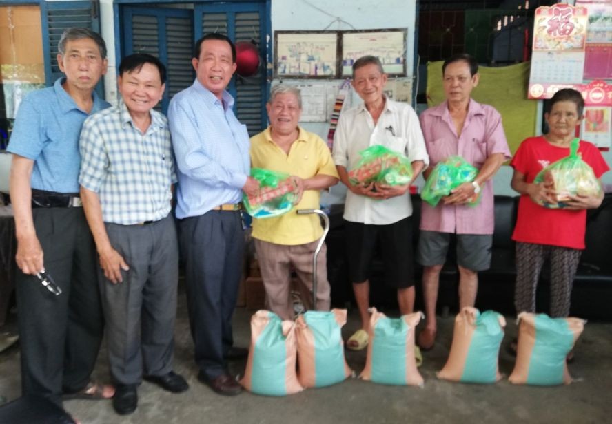 热心厂商杨庆文(左三)和玻璃业团主席李国强(左二)向团员发放新年礼物。