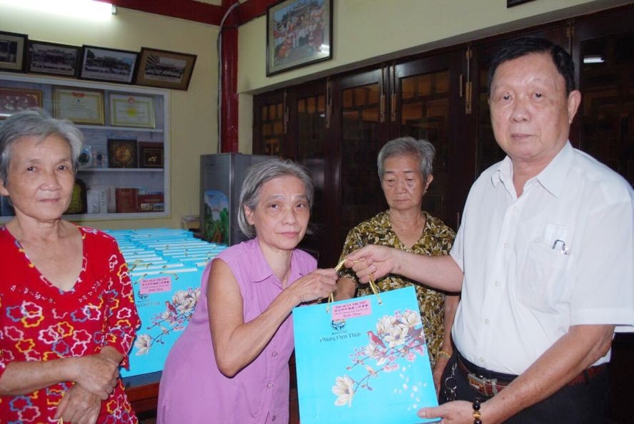 二府会馆副理事长谢忠成向高龄乡亲赠送礼物。
