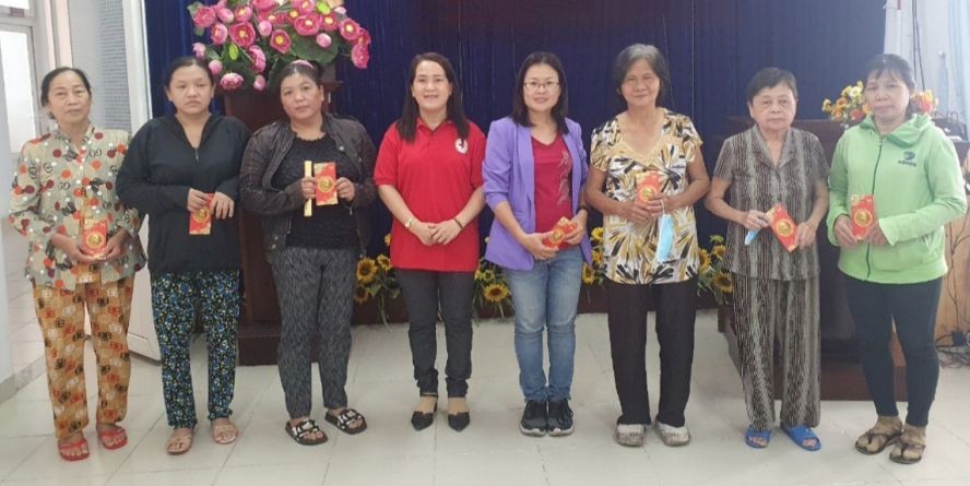 报社慈善组组长李爱清(左五)向第八郡华人送礼。