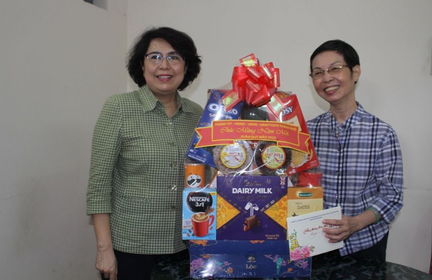 市委常务处委员、第一郡郡委书记苏氏碧珠（左）向华人退休干部姚妙玲赠送贺年礼物。