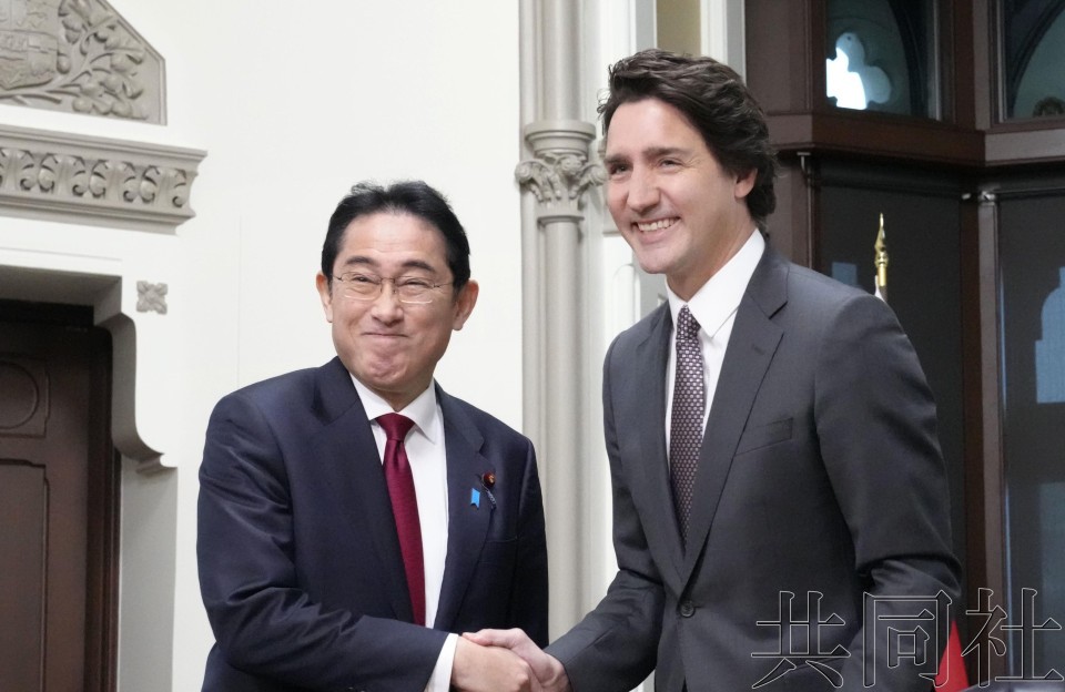 日本首相岸田文雄（左）和加拿大总理特鲁多在首脑会谈中握手。