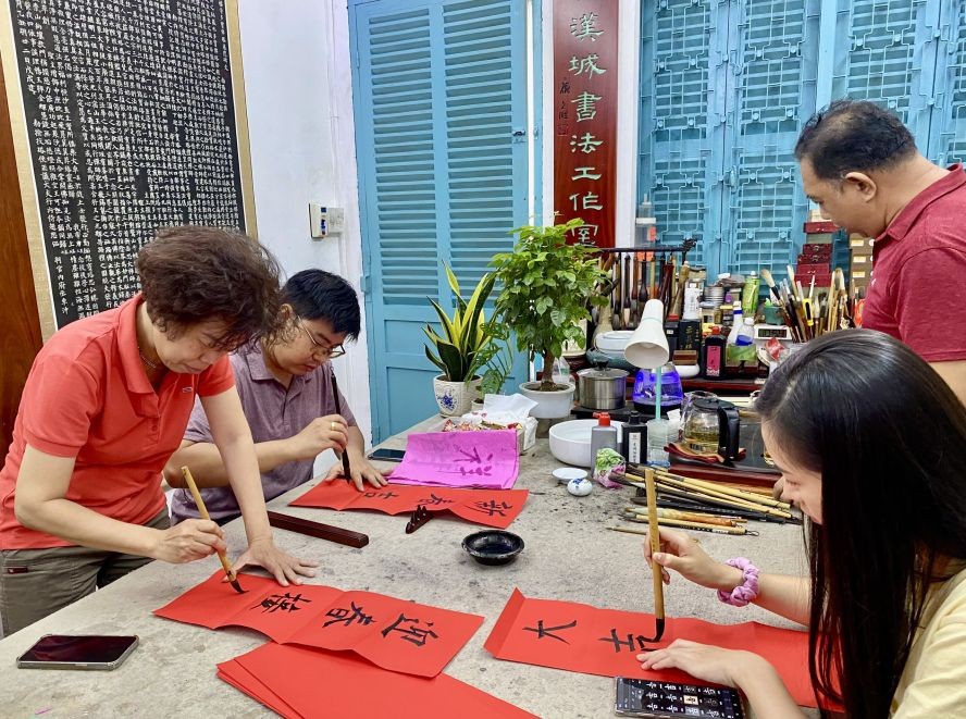 学员在聚会上挥毫挥春。