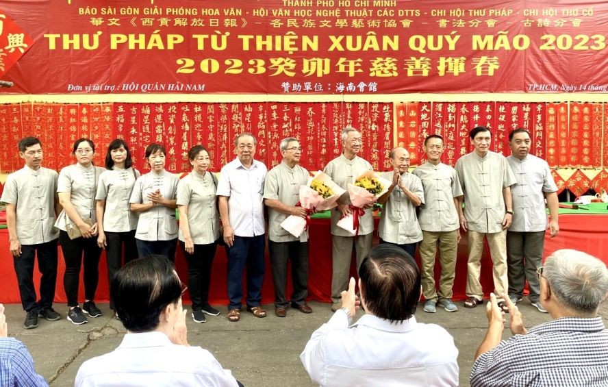 海南会馆常值副理事长孙盛强（左六）向各书法家赠送鲜花。