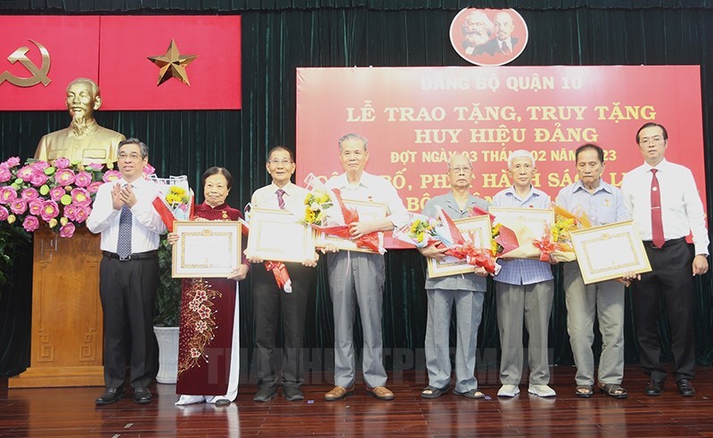 第十郡领导向当地高龄党员颁授党龄纪念章。（图：市党部新闻网）