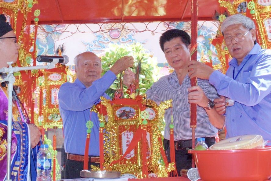 守德市七府关帝庙代表向江杰华（右二）移交“合家平安”圣灯。