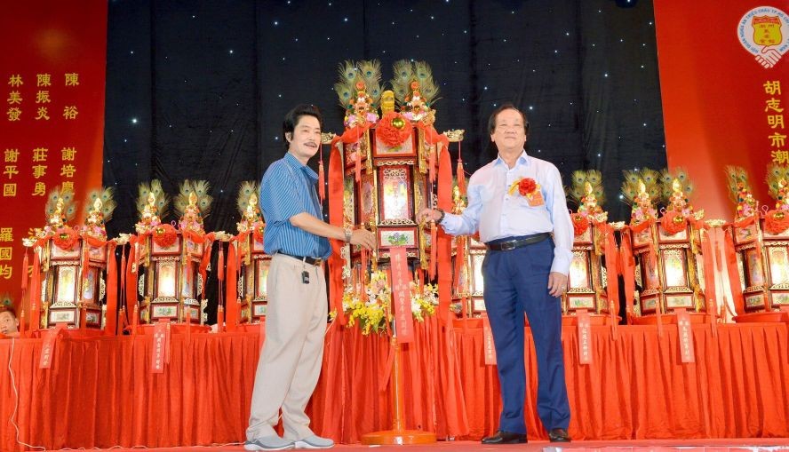 义安会馆荣誉理事长陈明向陈清平移交“关圣帝君财灯”。