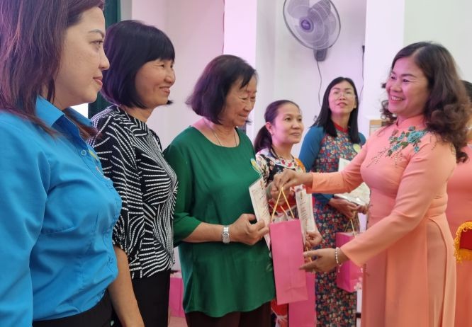 第五郡劳动联团主席黎氏碧幸向女职工颁发模范奖。