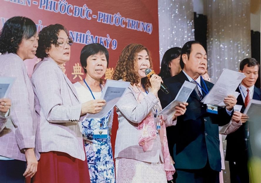 何丽娟（左四）与校园高唱校歌。