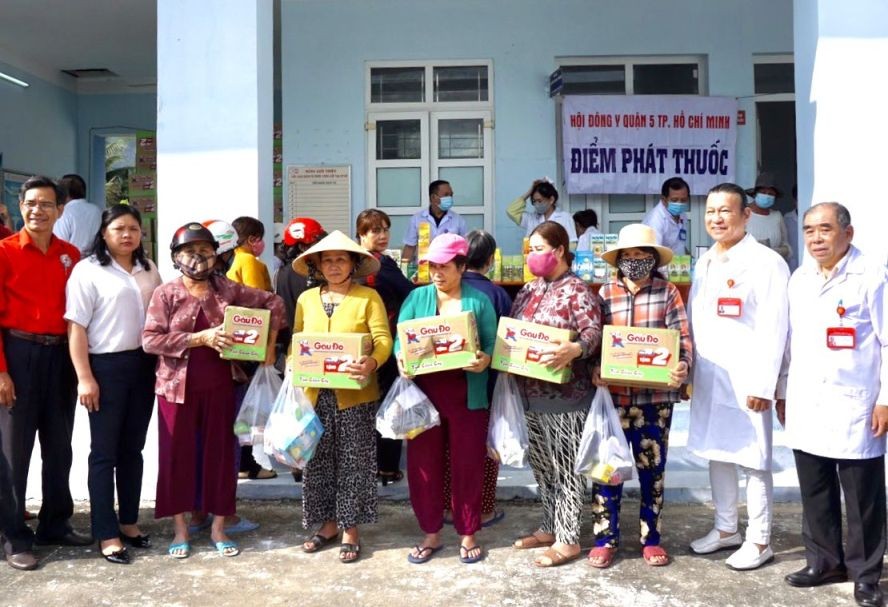 第五郡东医会领导（右一右二）与地方领导向病人发送药品与方便面。